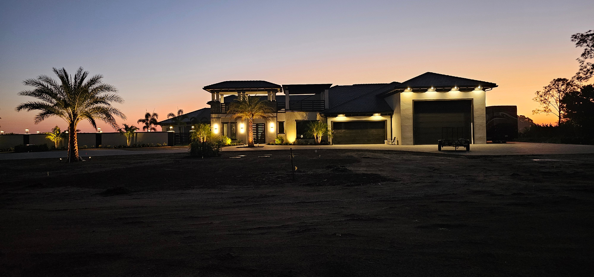 Luxury estate at dusk with full exterior lighting