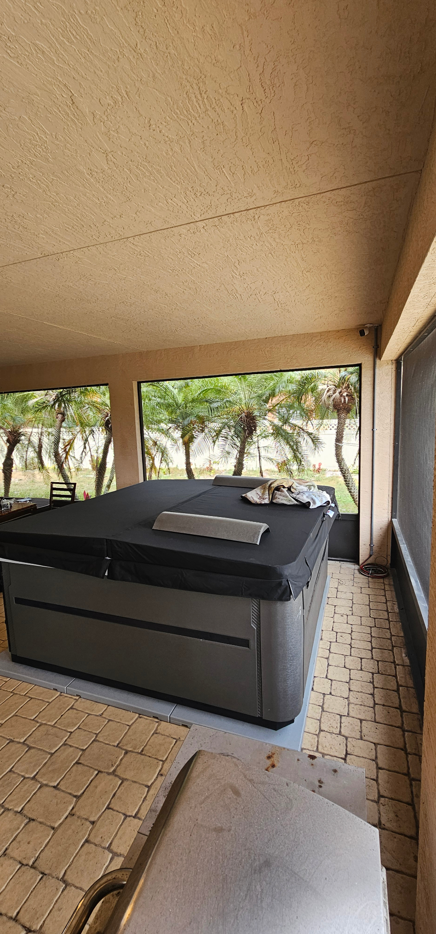 Outdoor hot tub installation wired and powered on a screened patio