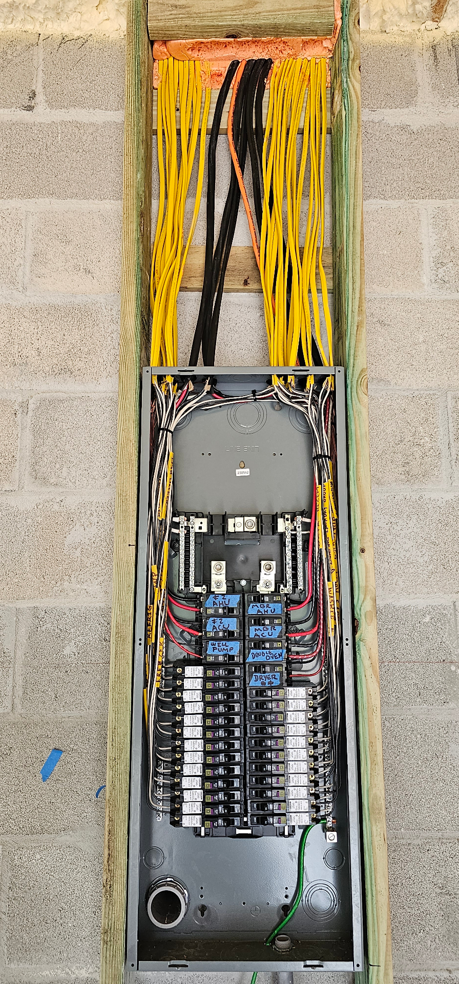 New construction rough-in panel with neatly bundled romex feeds