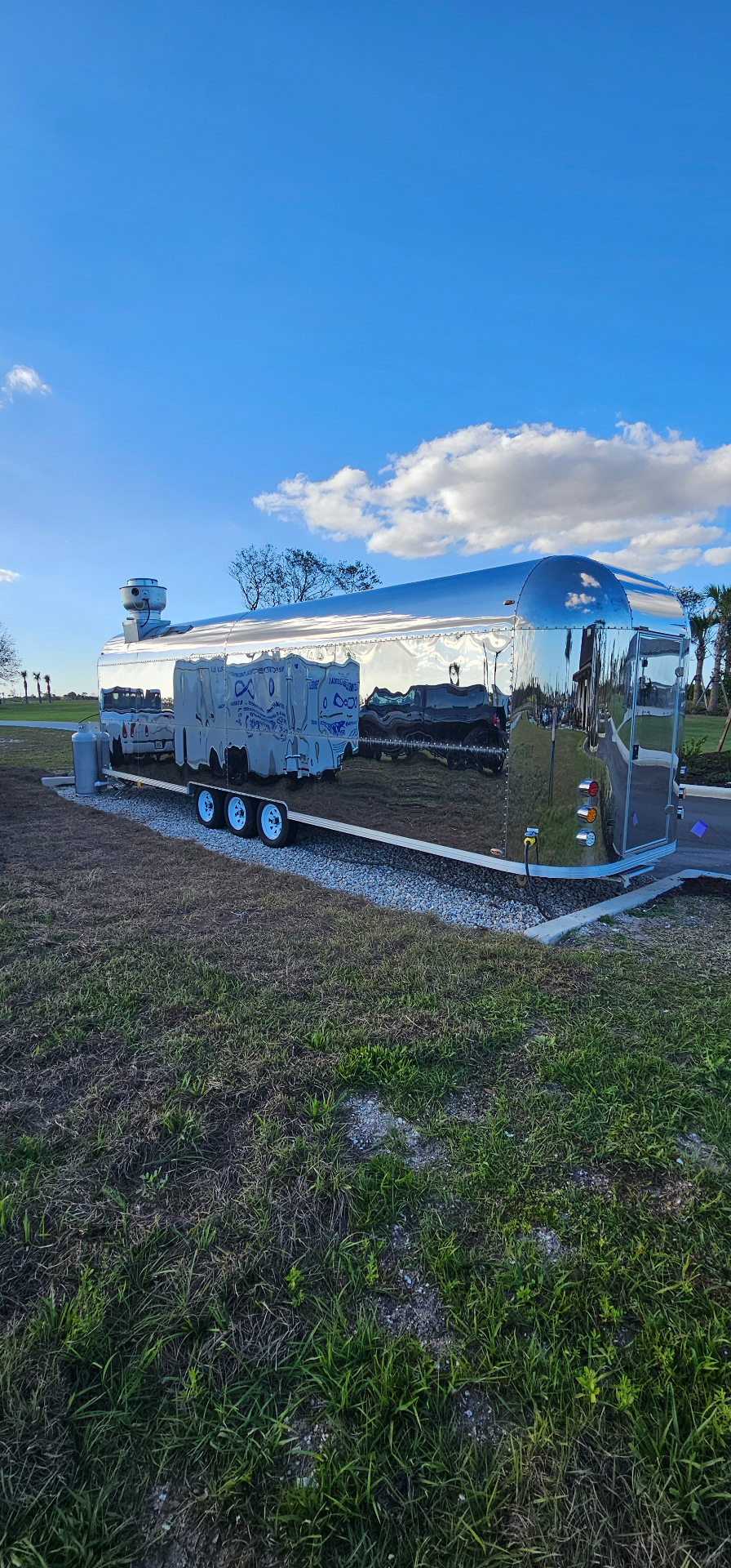 Mobile food trailer parked at a commercial site, ready for power hookup
